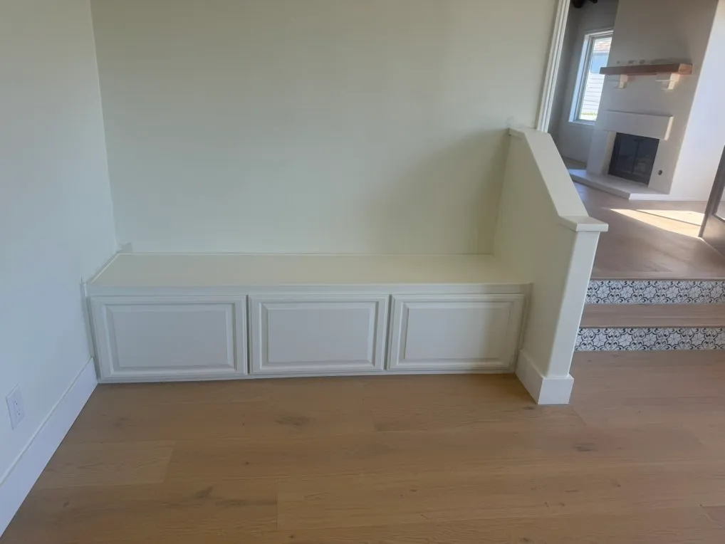 White wainscoting and baseboard beside hardwood flooring and stairs